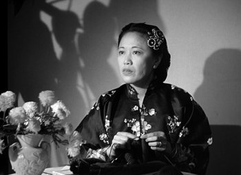 Movie still from “They Were Expendable” (1945), directed by Robert Montgomery – An older woman sitting in front of a vase of flowers; Close Up shot, Low angle