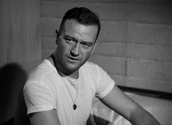 Movie still from “They Were Expendable” (1945), directed by Robert Montgomery – Black and white photograph of a man in a white t - shirt; Close Up shot, Low angle