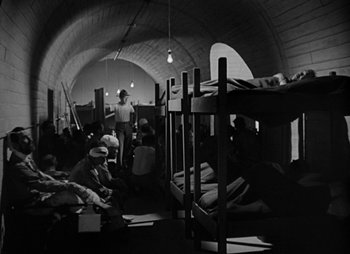 Movie still from “They Were Expendable” (1945), directed by Robert Montgomery – A group of people sitting on top of bunkbeds; Wide shot, High angle
