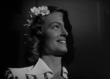 Movie still from “They Were Expendable” (1945), directed by Robert Montgomery – A black and white photo of a woman with a flower in her hair; Close Up shot, Low angle