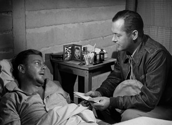 Movie still from “They Were Expendable” (1945), directed by Robert Montgomery – An old black and white photo of two men in a room; Medium shot, Over the shoulder angle