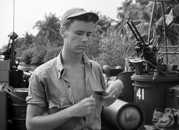 Movie still from “They Were Expendable” (1945), directed by Robert Montgomery – A man holding a cigarette in his hand; Medium shot, High angle