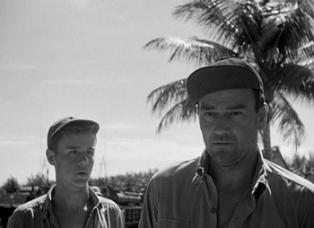 Movie still from “They Were Expendable” (1945), directed by Robert Montgomery – A black and white photo of two men standing next to each other; Medium shot, Low angle