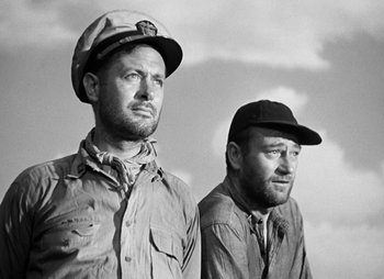 Movie still from “They Were Expendable” (1945), directed by Robert Montgomery – A black and white photo of two men standing next to each other; Medium shot, Low angle