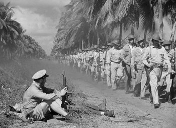 Movie still from “They Were Expendable” (1945), directed by Robert Montgomery – An old photo of a man sitting in front of a line of soldiers; Wide shot, High angle
