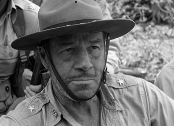 Movie still from “They Were Expendable” (1945), directed by Robert Montgomery – A man wearing a hat and a uniform; Close Up shot, Over the shoulder angle