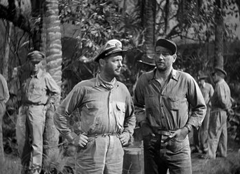 Movie still from “They Were Expendable” (1945), directed by Robert Montgomery – A black and white photo of two men standing next to each other; Medium shot, High angle