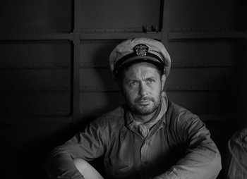 Movie still from “They Were Expendable” (1945), directed by Robert Montgomery – Black and white photograph of a man wearing a sailor's hat; Close Up shot, High angle