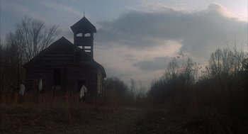 Movie still from “Thieves Like Us” (1974), directed by Robert Altman – An old abandoned house with a steeple in the background; Extreme Wide shot, Low angle