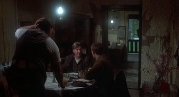 Movie still from “Thieves Like Us” (1974), directed by Robert Altman – A group of people sitting at a table in a room; Wide shot, Over the shoulder angle