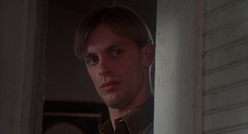 Movie still from “Thieves Like Us” (1974), directed by Robert Altman – A young man is standing next to a white wall; Close Up shot, Low angle