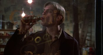 Movie still from “Thieves Like Us” (1974), directed by Robert Altman – A man is drinking a beer from a bottle; Close Up shot, Low angle