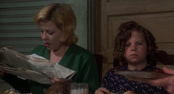 Movie still from “Thieves Like Us” (1974), directed by Robert Altman – Two women are sitting at a table reading newspapers; Medium shot, Over the shoulder angle