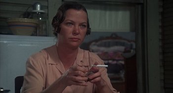 Movie still from “Thieves Like Us” (1974), directed by Robert Altman – A woman holding a cigarette and a cell phone; Close Up shot, Over the shoulder angle