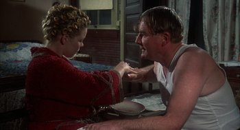 Movie still from “Thieves Like Us” (1974), directed by Robert Altman – A man and a woman are playing a game of tug - o - war; Medium shot, Low angle