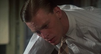 Movie still from “Thieves Like Us” (1974), directed by Robert Altman – A man in a white dress shirt and a brown tie; Close Up shot, Low angle