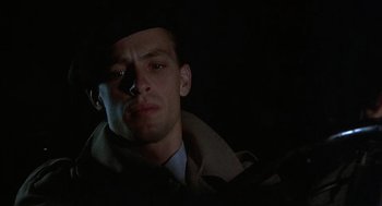 Movie still from “Thieves Like Us” (1974), directed by Robert Altman – A man in a hat and a trench coat looking at the camera; Close Up shot, Low angle