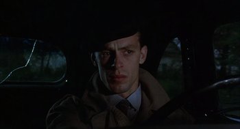 Movie still from “Thieves Like Us” (1974), directed by Robert Altman – A man wearing a hat sitting in the back of a car; Close Up shot, Low angle