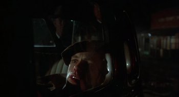 Movie still from “Thieves Like Us” (1974), directed by Robert Altman – A man in a car at night with his mouth open; Close Up shot, Low angle