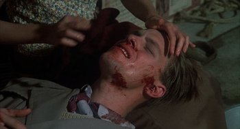 Movie still from “Thieves Like Us” (1974), directed by Robert Altman – A man with blood all over his face and neck; Close Up shot, High angle