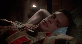 Movie still from “Thieves Like Us” (1974), directed by Robert Altman – A man laying in a bed with a blanket on top of him; Close Up shot, High angle