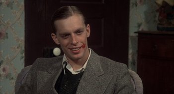 Movie still from “Thieves Like Us” (1974), directed by Robert Altman – A young man with a red lipstick mark on his face; Close Up shot, High angle