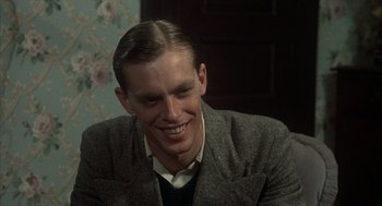 Movie still from “Thieves Like Us” (1974), directed by Robert Altman – A man in a suit smiling for the camera; Close Up shot, High angle