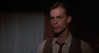 Movie still from “Thieves Like Us” (1974), directed by Robert Altman – A man wearing a vest and a neck tie; Close Up shot, Low angle