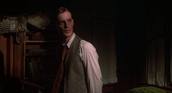 Movie still from “Thieves Like Us” (1974), directed by Robert Altman – A man wearing a suit and tie standing in a room; Close Up shot, Over the shoulder angle