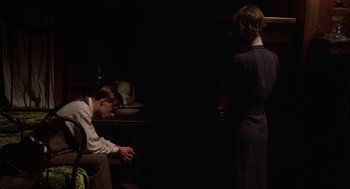 Movie still from “Thieves Like Us” (1974), directed by Robert Altman – A man and a woman standing next to each other in a dark room; Medium shot, High angle