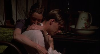 Movie still from “Thieves Like Us” (1974), directed by Robert Altman – A man and a woman hugging in a dark room; Medium shot, High angle