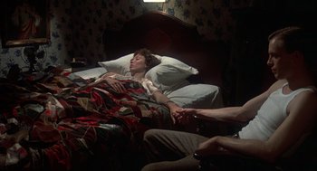 Movie still from “Thieves Like Us” (1974), directed by Robert Altman – A woman laying in a bed next to another woman; Medium shot, High angle