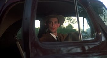 Movie still from “Thieves Like Us” (1974), directed by Robert Altman – A man wearing a hat sitting in the back seat of a car; Close Up shot, Low angle