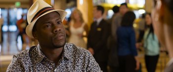 Movie still from “Think Like a Man Too” (2014), directed by Tim Story – A person wearing a hat with people in the background; Close Up shot, Over the shoulder angle