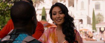 Movie still from “Think Like a Man Too” (2014), directed by Tim Story – A woman in a pink and orange dress smiling at the camera; Close Up shot, Over the shoulder angle