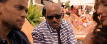 Movie still from “Think Like a Man Too” (2014), directed by Tim Story – A bald man wearing a striped shirt and sunglasses; Close Up shot, Over the shoulder angle