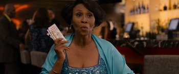 Movie still from “Think Like a Man Too” (2014), directed by Tim Story – An older woman holding a boarding pass in her hand; Close Up shot, Over the shoulder angle
