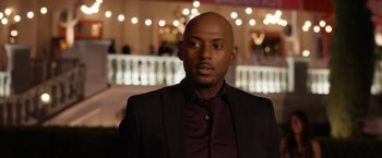 Movie still from “Think Like a Man Too” (2014), directed by Tim Story – A man wearing a suit and a maroon shirt; Close Up shot, Over the shoulder angle