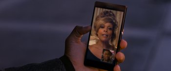 Movie still from “Think Like a Man Too” (2014), directed by Tim Story – A person holding up a cell phone to take a picture of a woman; Close Up shot, High angle