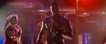 Movie still from “Think Like a Man Too” (2014), directed by Tim Story – A man with no shirt is holding a microphone; Medium shot, Low angle