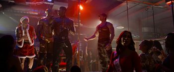 Movie still from “Think Like a Man Too” (2014), directed by Tim Story – A couple of men standing next to each other in front of a microphone; Medium shot, Over the shoulder angle