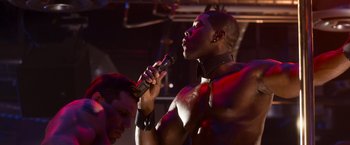 Movie still from “Think Like a Man Too” (2014), directed by Tim Story – A man that is holding a microphone in his hand; Close Up shot, Over the shoulder angle