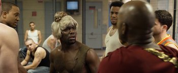 Movie still from “Think Like a Man Too” (2014), directed by Tim Story – A man with a leopard print wig and a leopard head wrap; Medium shot, Over the shoulder angle