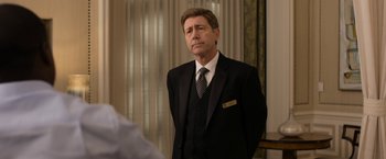 Movie still from “Think Like a Man Too” (2014), directed by Tim Story – A man in a suit and tie standing in front of a window; Medium shot, Over the shoulder angle