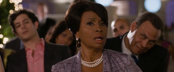 Movie still from “Think Like a Man Too” (2014), directed by Tim Story – An older woman wearing a purple jacket and pearl necklace; Close Up shot, Over the shoulder angle