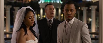 Movie still from “Think Like a Man Too” (2014), directed by Tim Story – A man and a woman standing in front of a man in a suit; Close Up shot, Over the shoulder angle