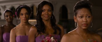 Movie still from “Think Like a Man Too” (2014), directed by Tim Story – A woman in a purple dress holding a bouquet of flowers; Close Up shot, Over the shoulder angle