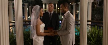 Movie still from “Think Like a Man Too” (2014), directed by Tim Story – A bride and groom holding hands at their wedding ceremony; Medium shot, Over the shoulder angle