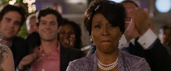 Movie still from “Think Like a Man Too” (2014), directed by Tim Story – An older woman with short black hair wearing a purple jacket; Close Up shot, Over the shoulder angle