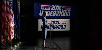 Movie still from “House of Cards” (2013), created by Beau Willimon – A woman standing in front of a microphone on a stage; Medium shot, Low angle